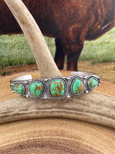 green turquoise cuff on wooden background