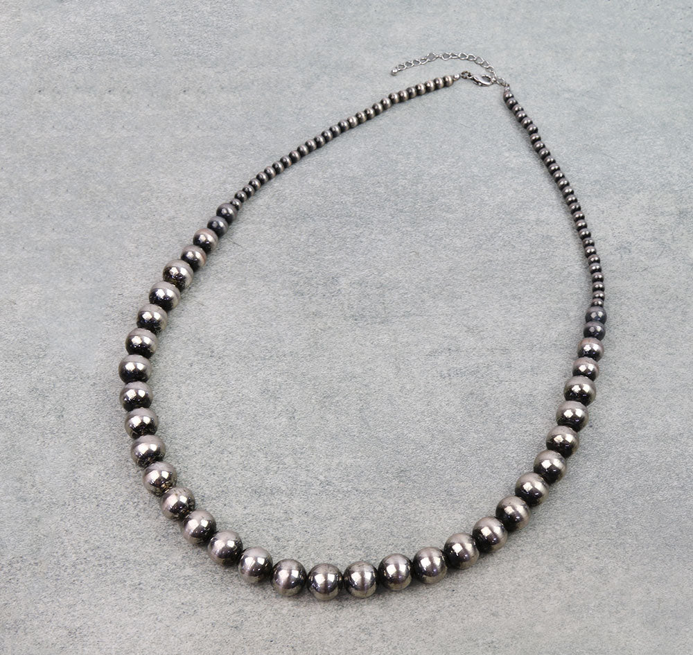 Necklace with black beads on a gray background