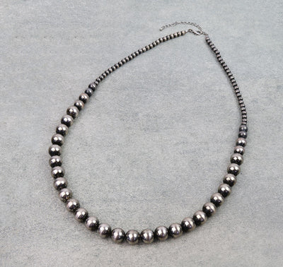 Necklace with black beads on a gray background