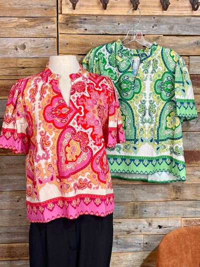 Two patterned tops displayed against a wooden wall.