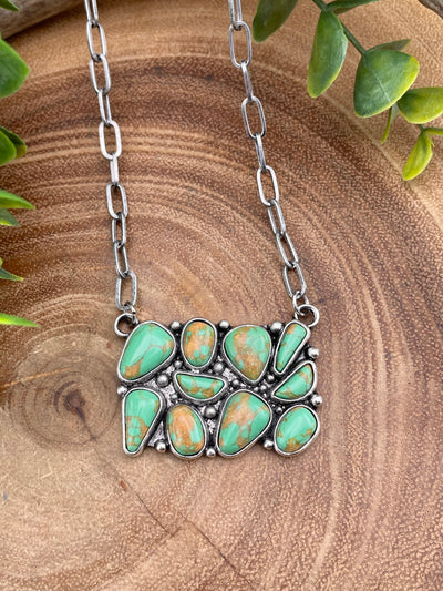 green turquoise cluster necklace on wooden background