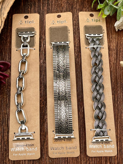 Three different watch bands on a wooden surface.