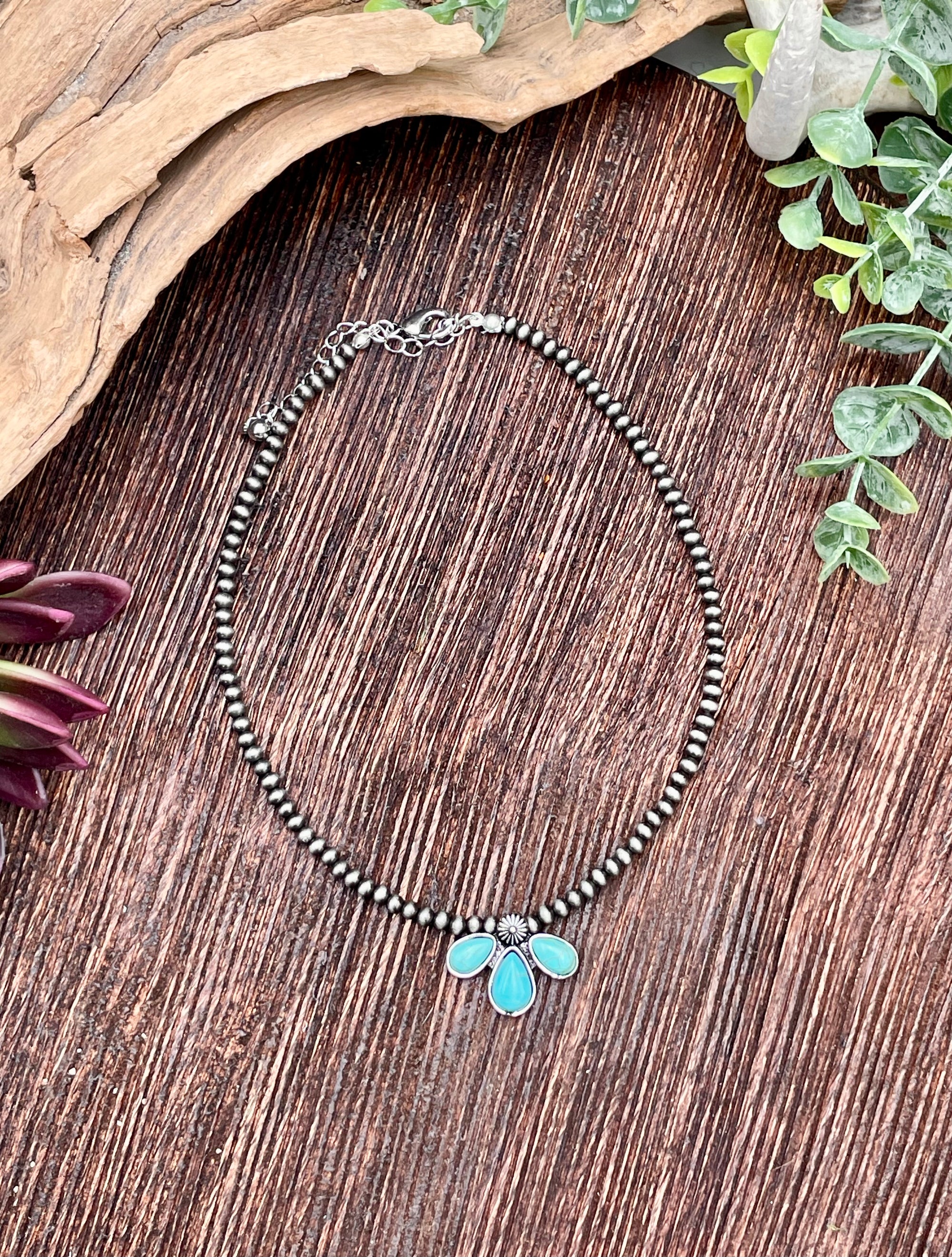 Necklace with turquoise pendant on a wooden surface