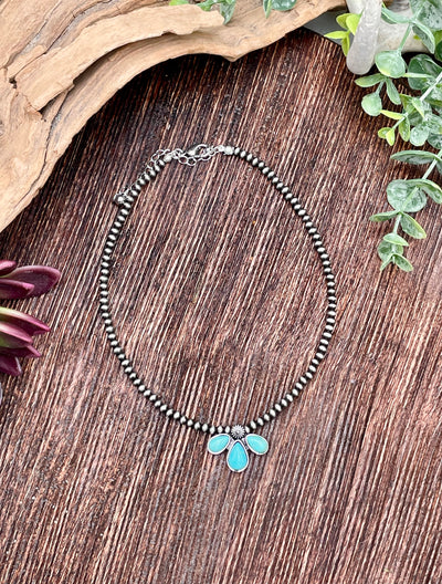 Necklace with turquoise pendant on a wooden surface