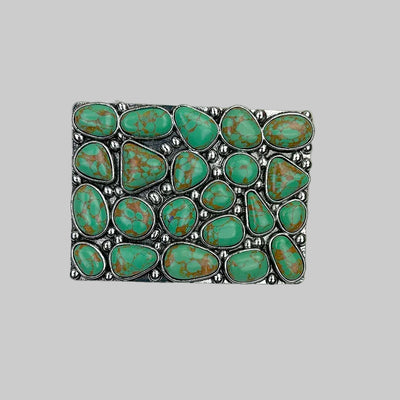 Turquoise stone belt buckle on a light gray background
