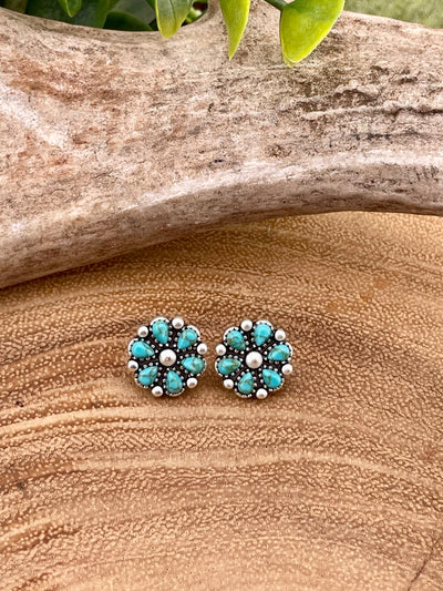Turquoise stud earrings on a wooden surface
