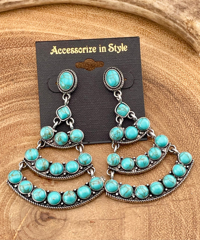 blue chandelier earrings on a wooden surface