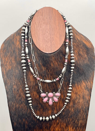 Necklace with pink pendant on a wooden mannequin