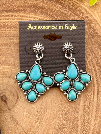 Turquoise teardrop earrings on a 'Accessorize in Style' card against a wooden background
