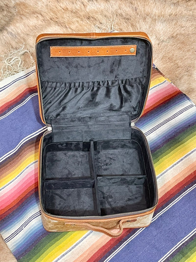 Open jewelry case with compartments on a colorful striped fabric background
