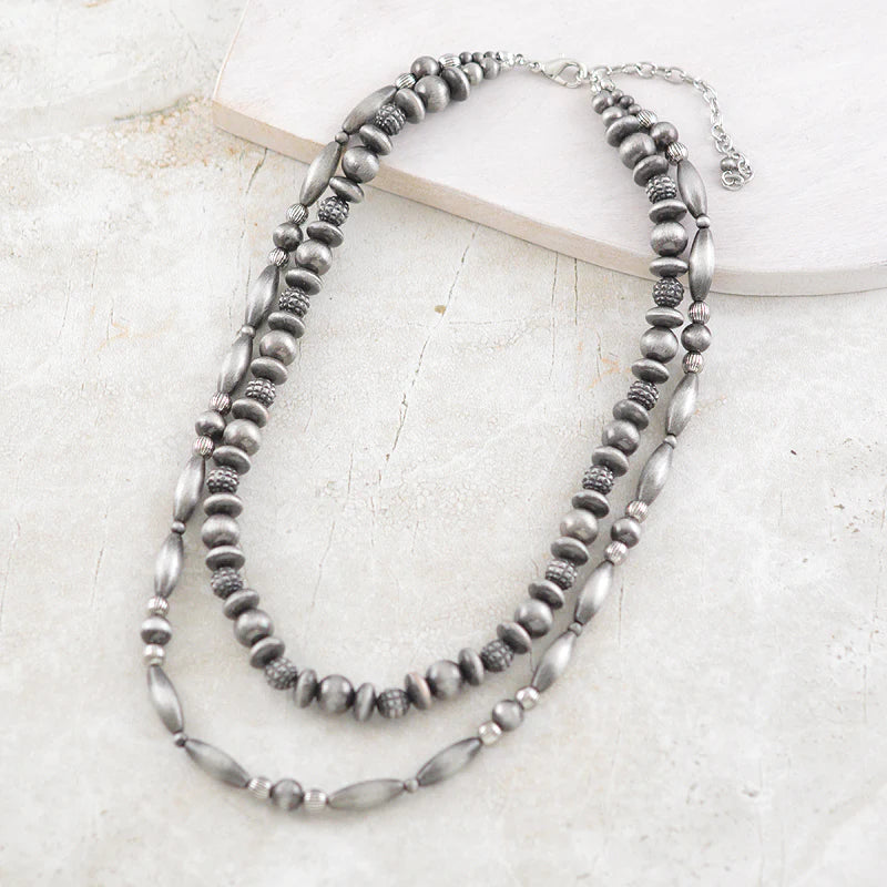 double strand silver bead necklace on white background