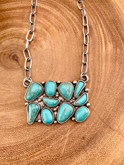 turquoise cluster necklace on wooden background