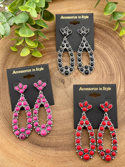 Three pairs of earrings on cards labeled 'Accessorize in Style' with green leaves in the background.