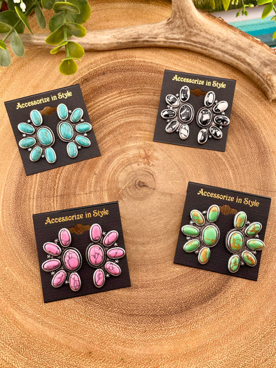four pairs of earrings on a wooden background