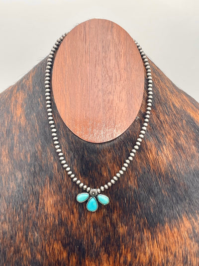 Necklace with turquoise pendant on a wooden mannequin head