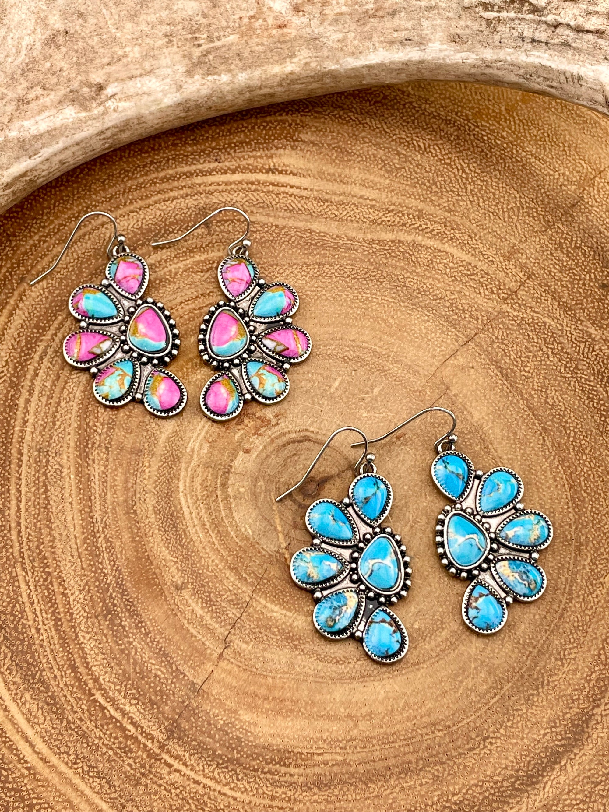 Earrings with pink and blue stones on a wooden surface