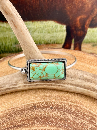 green rectangle stone bracelet on wooden display