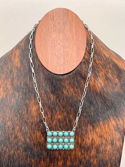 Necklace with turquoise pendant on a wooden stand