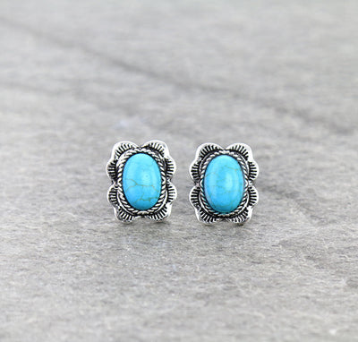 Turquoise stone stud earrings with silver setting on a gray background