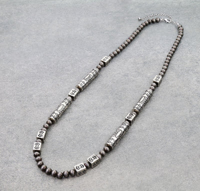 Necklace with brown beads and silver accents on a gray background