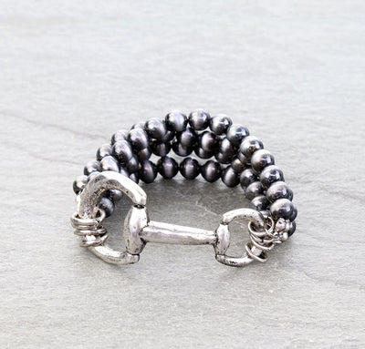 multi strand silver bit stretch bracelet on a gray background
