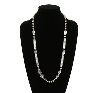 Pearl necklace with silver accents on a black mannequin against a white background