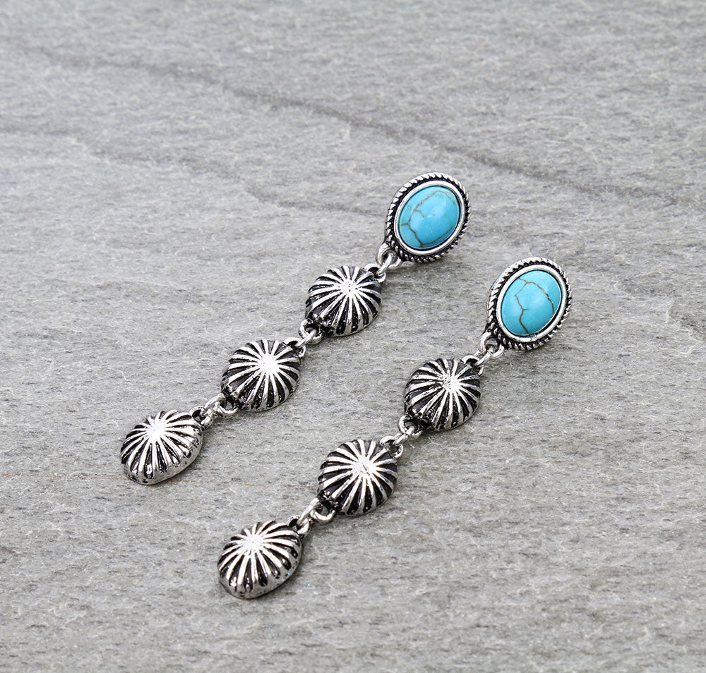 Silver earrings with turquoise stones on a gray background