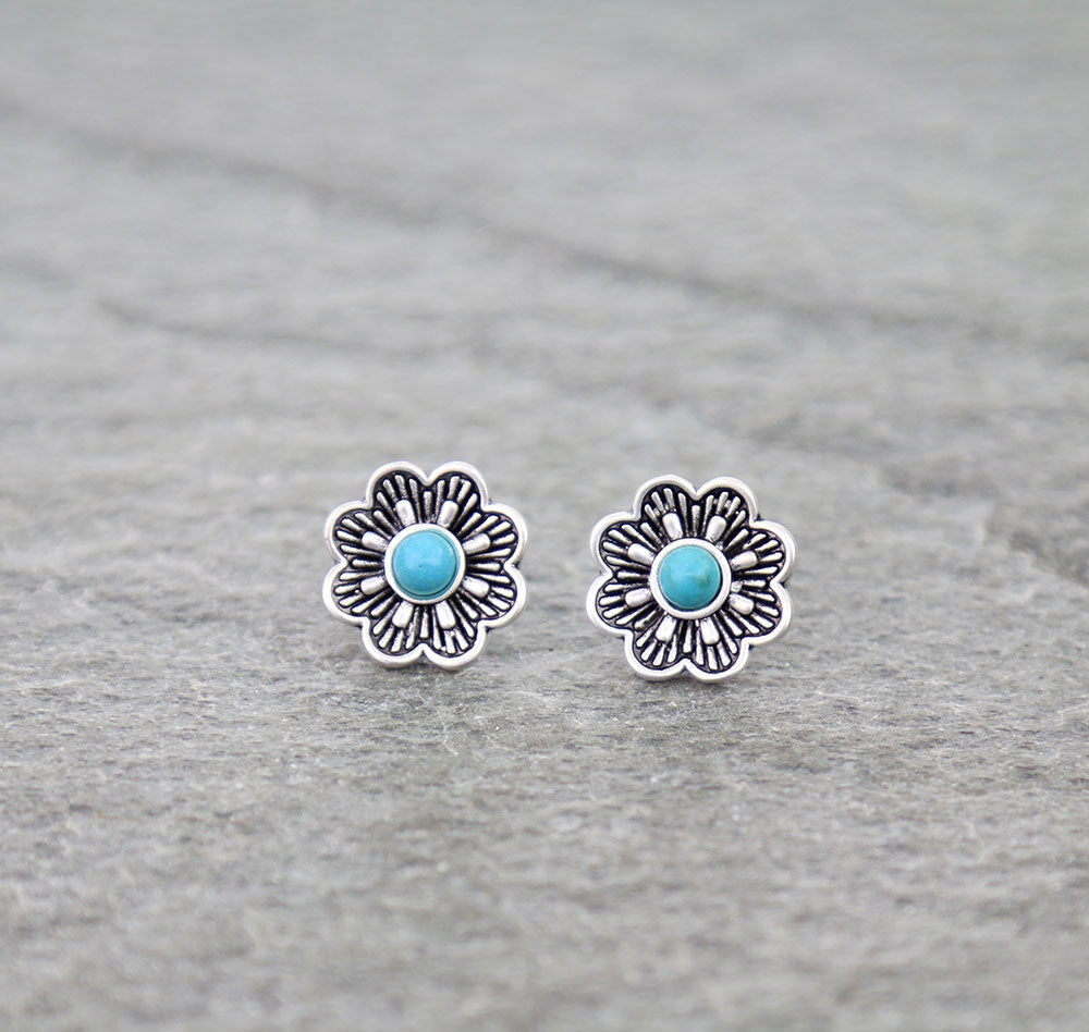 Floral earrings with turquoise centers on a gray background