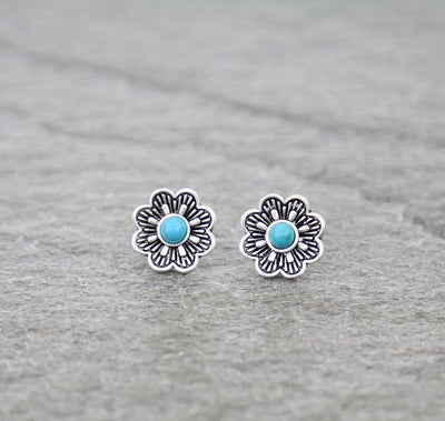 Floral earrings with turquoise centers on a gray background