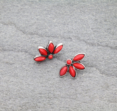 Red flower-shaped earrings on a gray background