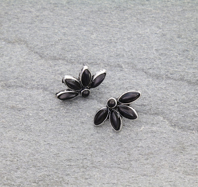 Floral silver earrings with black stones on a gray background