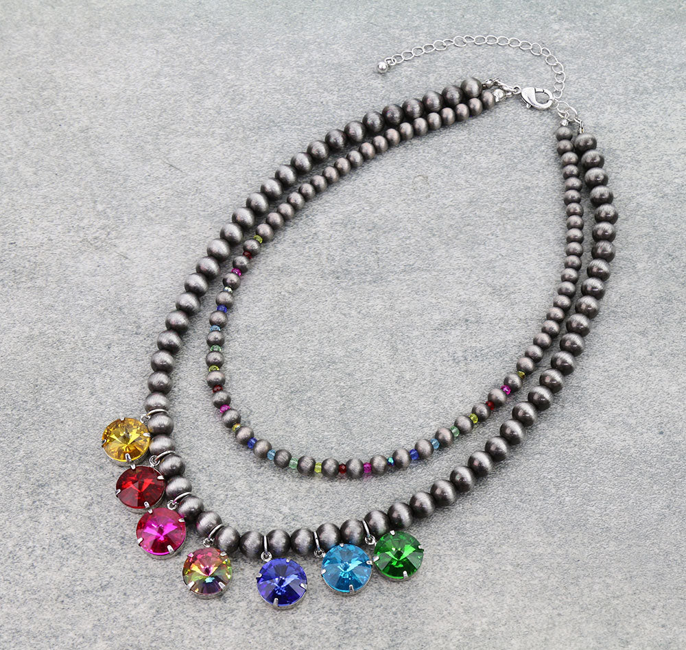 Double strand silver bead necklace with multi color stones on a gray background.