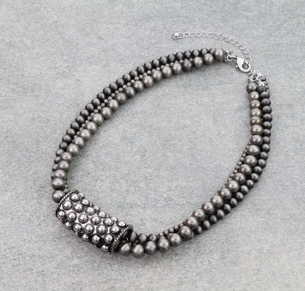 Necklace with silver beads on a light gray background