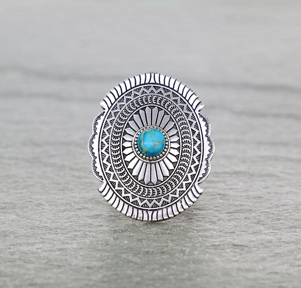 Concho ring with turquoise center on a gray background