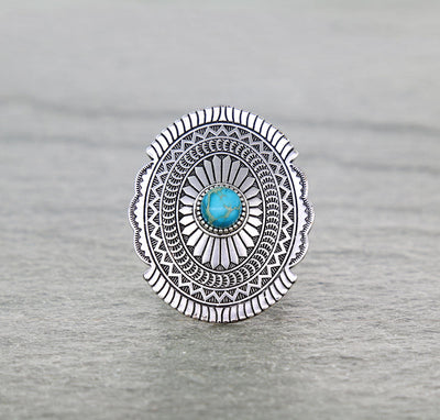 Concho ring with turquoise center on a gray background