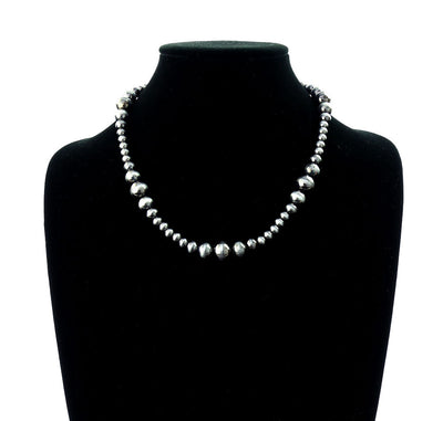 Silver beaded necklace on a black mannequin with a white background