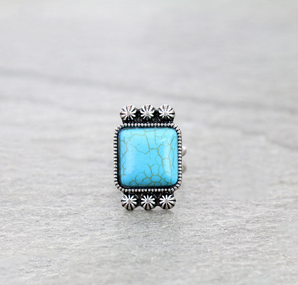 Ring with turquoise stone and silver accents on a gray background