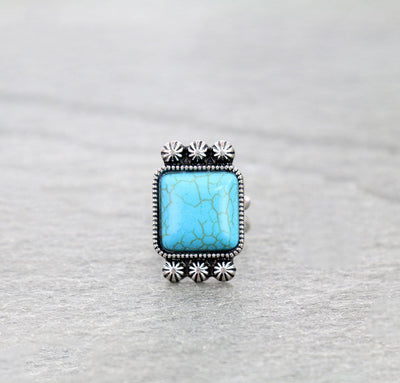Ring with turquoise stone and silver accents on a gray background