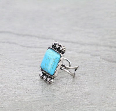 Silver ring with a turquoise stone on a gray background