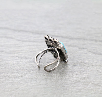 Silver ring with turquoise stone on a gray background