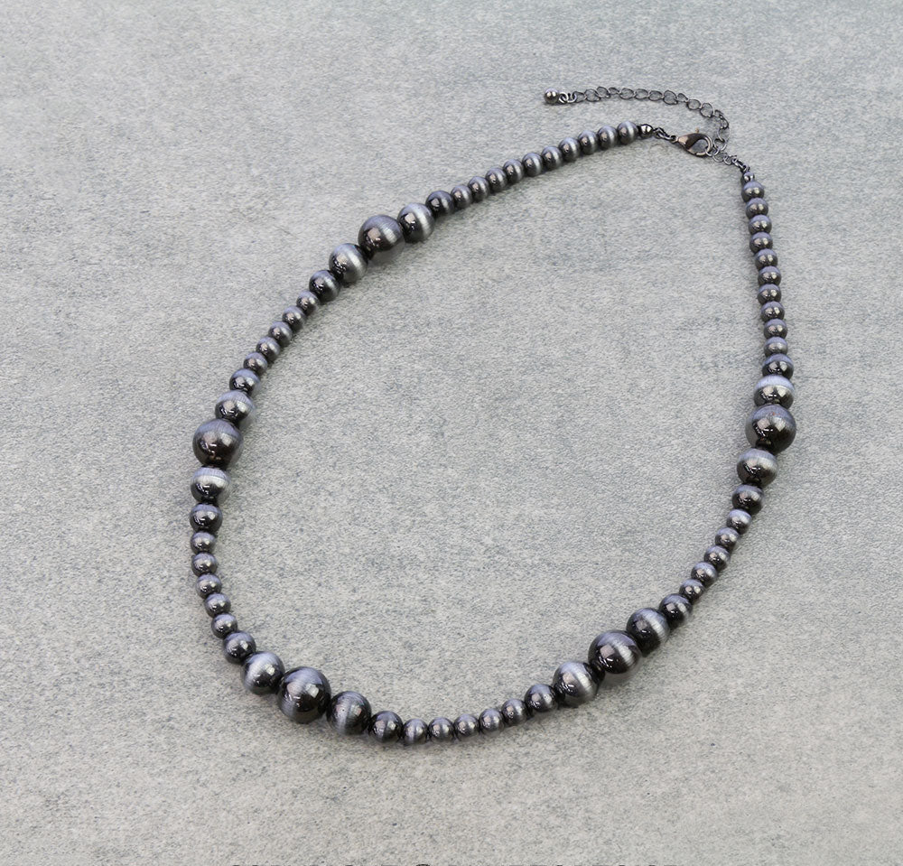 Necklace with silver beads on a light gray background