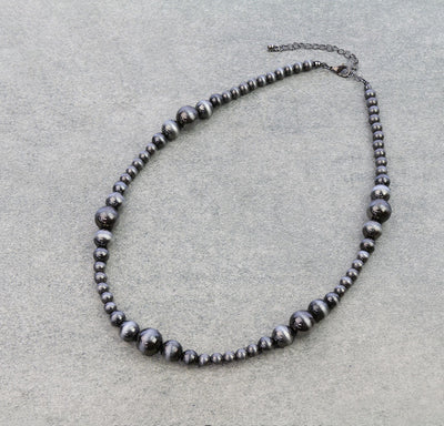 Necklace with silver beads on a light gray background