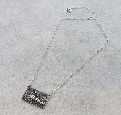 Silver necklace with a rectangular pendant on a gray background