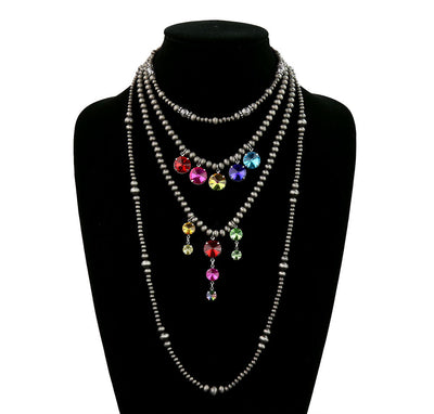 Necklace with multicolored gemstones on a black mannequin bust