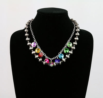 Necklace with colorful beads on a black mannequin against a white background