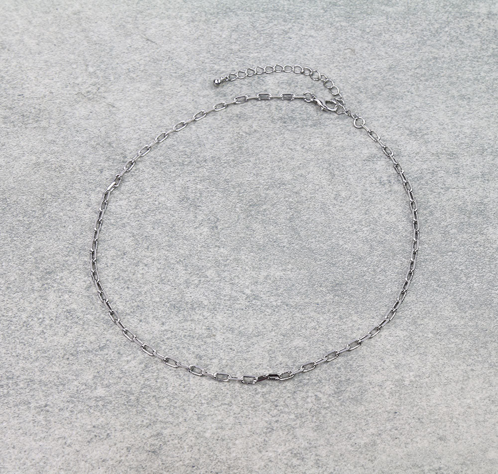 Silver chain necklace on a gray background