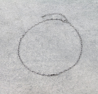 Silver chain necklace on a gray background