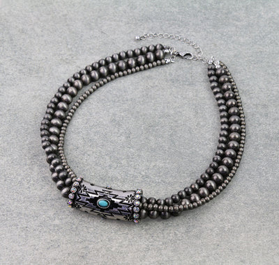 Necklace with beads and a decorative center on a gray background