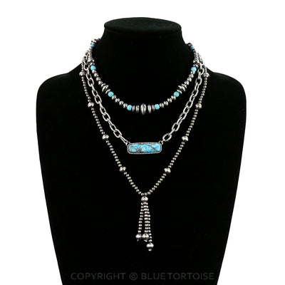 Necklace with turquoise stones on a black mannequin against a white background