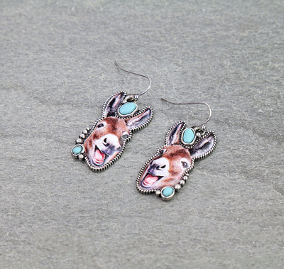 Pair of earrings with donkey designs on a gray background